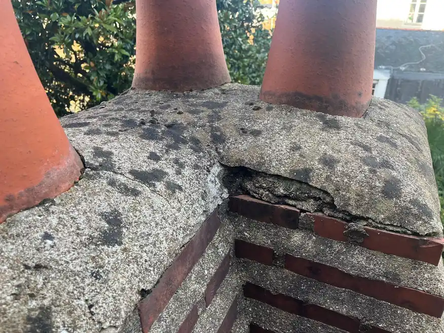 Souches de cheminée en terre cuite sur un couronnement maçonné dégradé
