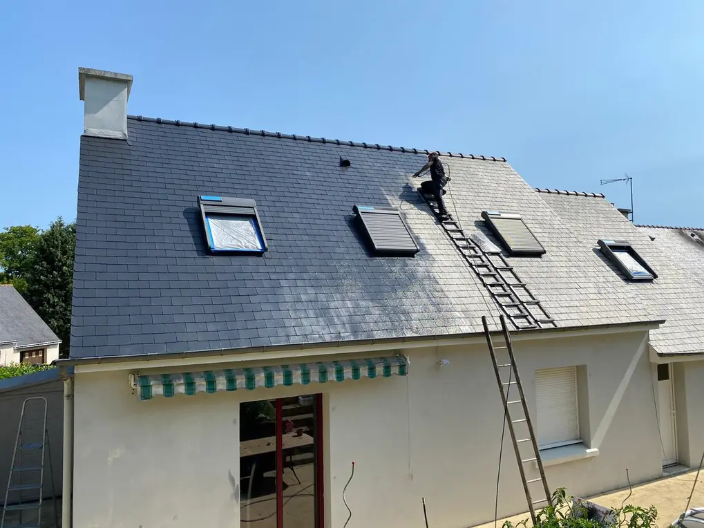 Maison en ardoise équipée de fenêtres de toit, échelle en façade
