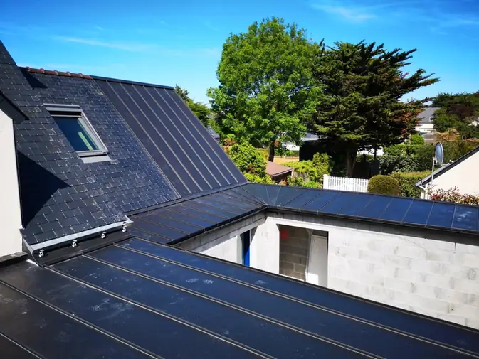 Couverture en zinc sombre avec fenêtre de toit, jardin en contrebas